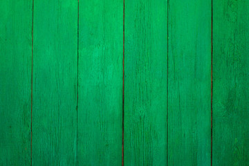 Vintage wooden texture of an old fence painted green. Vertical texture on background