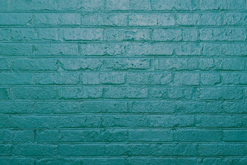 Vintage texture of old brick wall dyed in turquoise color. Painted facade of apartment house 