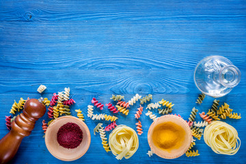 Fototapeta na wymiar Food ingredients for Italian pasta on blue wooden desk background top view copyspace