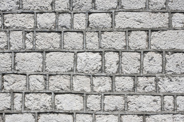 Gray brick wall made of uneven blocks pattern.