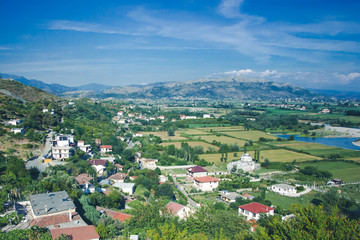 Fototapeta na wymiar Beautiful sunny summer landscape in Albania. View of Shkoder city from the top of the mountain.