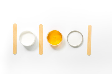 Concept depilation with wax and sticks on white background top view copyspace