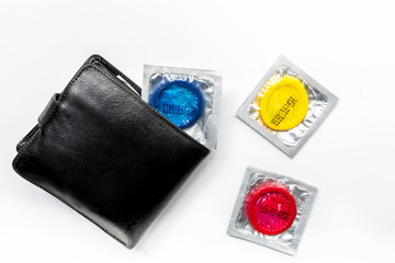 male contraception with condom and wallet on white background top view