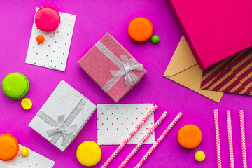 Birthday greeting cards and wrapped gifts on fuchsia background top view