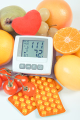 Blood pressure monitor, fruits with vegetables and medical pills, healthy lifestyle