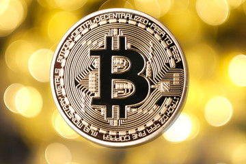 Golden bitcoin isolated on blurred light background