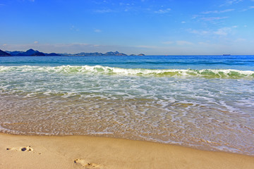 Water over sand in Cpacabana beach horizon with Rio de Janeiro hills