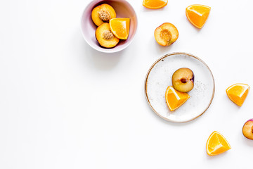 tropical peach and orange fruits for fresh juice on plates white background top view space for text