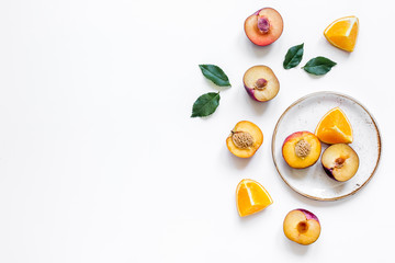 tropical peach and orange fruits for fresh juice on plates white background top view space for text