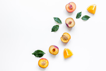 tropical fruits design with orange and peach on white table background top view mock up