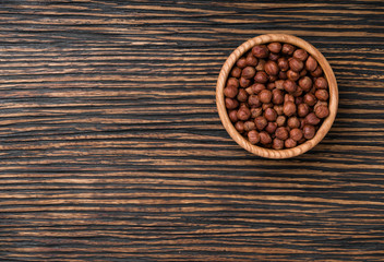 peeled hazelnuts on a brown wooden table,top view