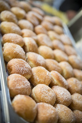 Donuts with icing sugar on baking pan heating in a wedding reception