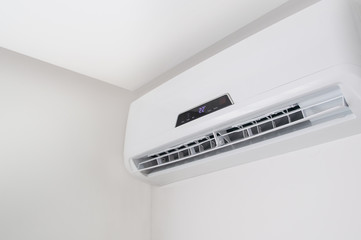 White split air conditioner closeup on a white wall. Home interior in a small apartment