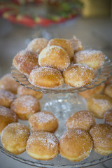 Donuts with icing sugar on baking pan heating in a wedding reception