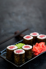 Fresh delicious tuna maki sushi rolls on dark background