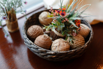 Wicker bowl with wicker balls. Decorative object asian wooden wicker spheres lay in wooden bowl with decorative elements of flowers