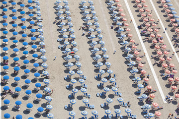 Top view of rows of umbrellas on a sandy beach in Viareggio, Italy