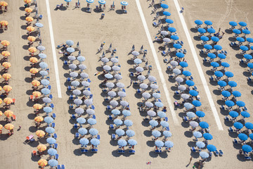 Top view of rows of umbrellas on a sandy beach in Viareggio, Italy