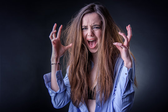 Maniac woman screaming, angry and frustrated, white background, very long hair