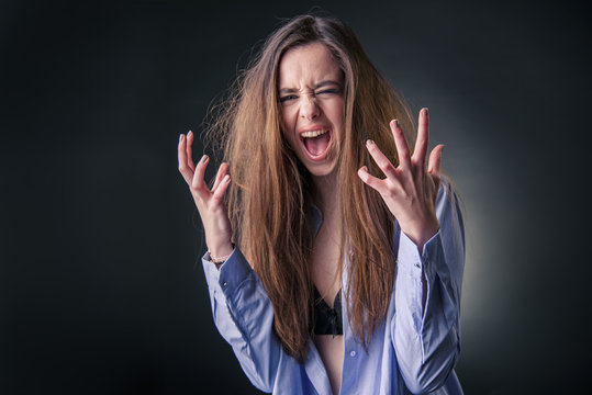 Maniac woman screaming, angry and frustrated, white background, very long hair