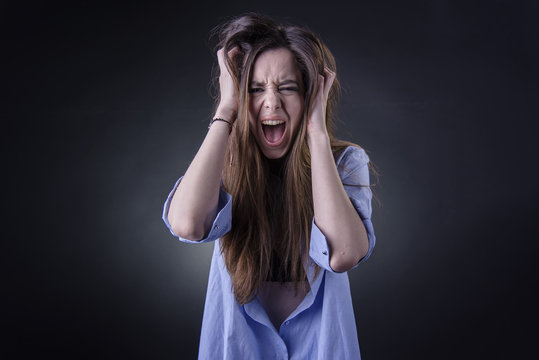 Maniac woman screaming, angry and frustrated, white background, very long hair