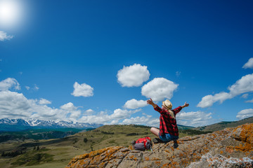 Young woman sitting in a National Park. Dream, looking at the mountains.