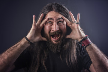 Crazy metalhead long haired man shaking his head and waving his hair, horror, dark and halloween