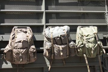 Three military style ruck sacks hanging on a truck