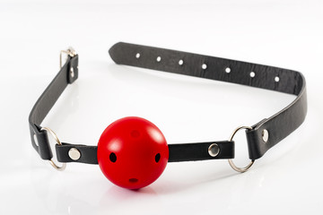 Fetish and kinky sex play and BDSM sex toys concept with a red ball gag toy isolated on white