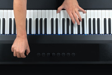 Pianist playing electric piano while modifying settings