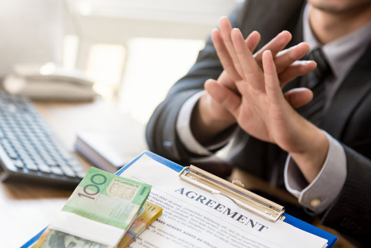 Businessman refusing money that come with agreement paper
