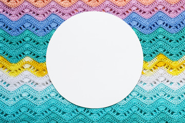 Crocheted multicolored cotton fabric In summer colors. Round white frame for text. © colnihko