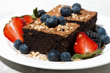 dessert - chocolate brownies with fresh berries on plate, closeup