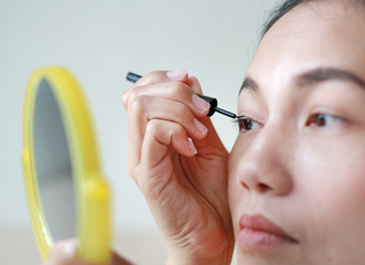 Portrait of beautiful woman making black eyeliner. Beauty Concept.