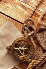 Fototapeta na wymiar compass and rope on old wooden boards