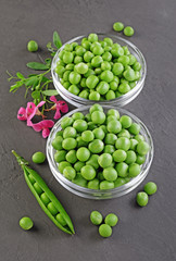 .Healthy food. Fresh green peas in glass bowls with pink flowers of sweet pea