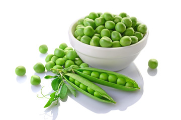 Healthy food. Fresh green peas in white bowl with pink flowers of sweet pea