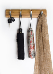 Man's and woman's accessories hang on hook rack, white background