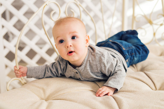 Adorable baby boy in sunny bedroom. Newborn child relaxing. Nursery for young children.Family morning at home. Little kid lying on tummy
