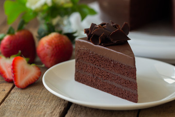 Homemade bakery: chocolate fudge cake decorated with chocolate curl. Triangle slice piece of...