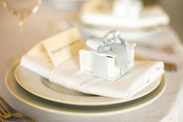 Fototapeta na wymiar Little present box stands on the white dinner plate