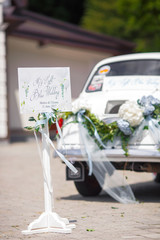 Card with lettering 'My light blue wedding' stands before the statue on the backyard