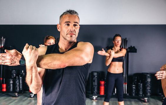 Portrait of man stretching arms in fitness class on sports center
