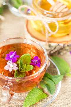 Glass cup of summer tea with herbs