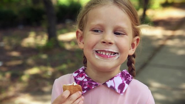 Adorable girl eating tasty ice cream hot summer day.