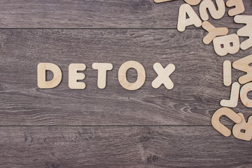 Word made with wooden letters next to a pile of other letters over the wooden board