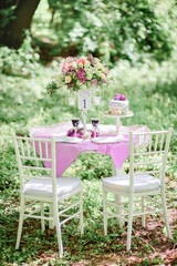 Table number one with bouquet of violet flowers and little cake on it