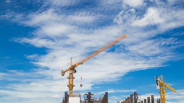 4k Time-lapse of construction crane and worker of building industry with blue sky 