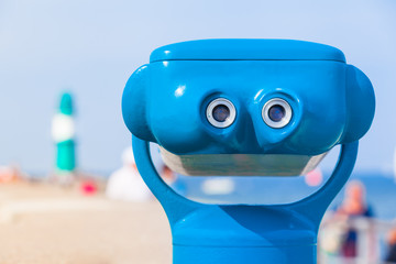 Telescope Eyepiece View to the Lighthouse / Ocular of blue telescope with beach background