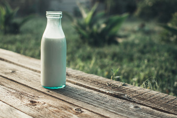 Bottle of fresh milk and glass on a wooden table